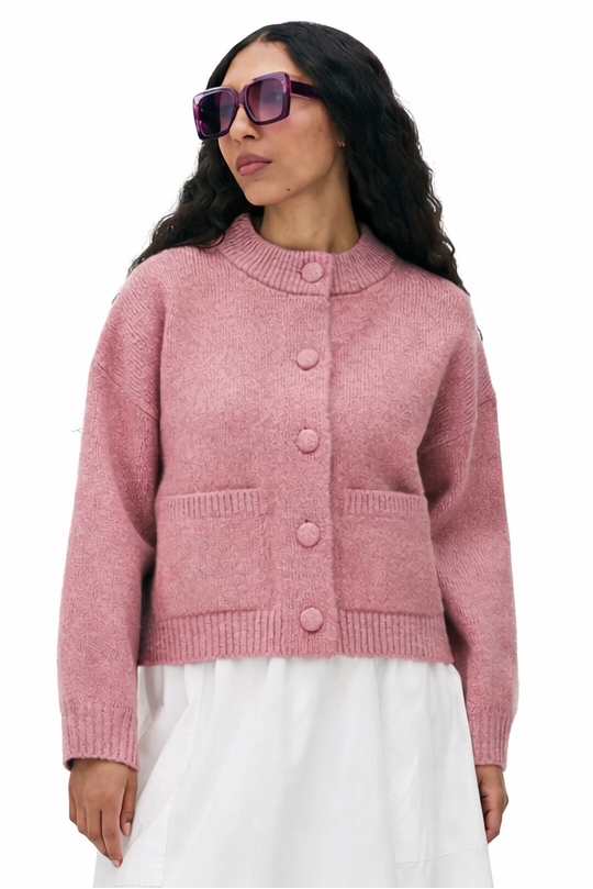 Woman wearing a pink cardigan and white skirt on a white background